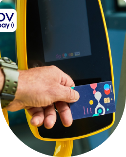 Een hand heeft een bankpas vast en checkt in bij een incheckautomaat in de bus